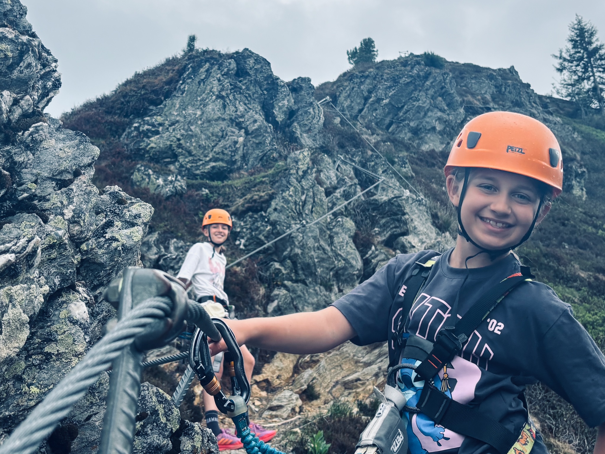 The two girls clipped onto their first via ferrata in helmets